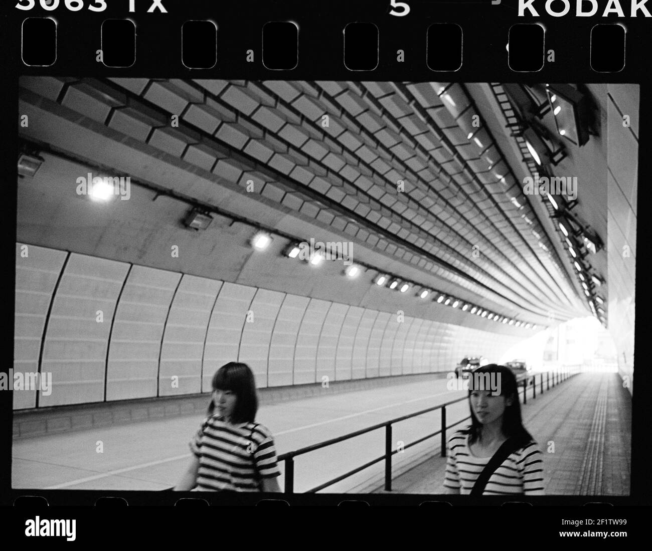 girls passing urban pedestrian tunnel with modern futuristic architecture in Tokyo, Japan Stock Photo