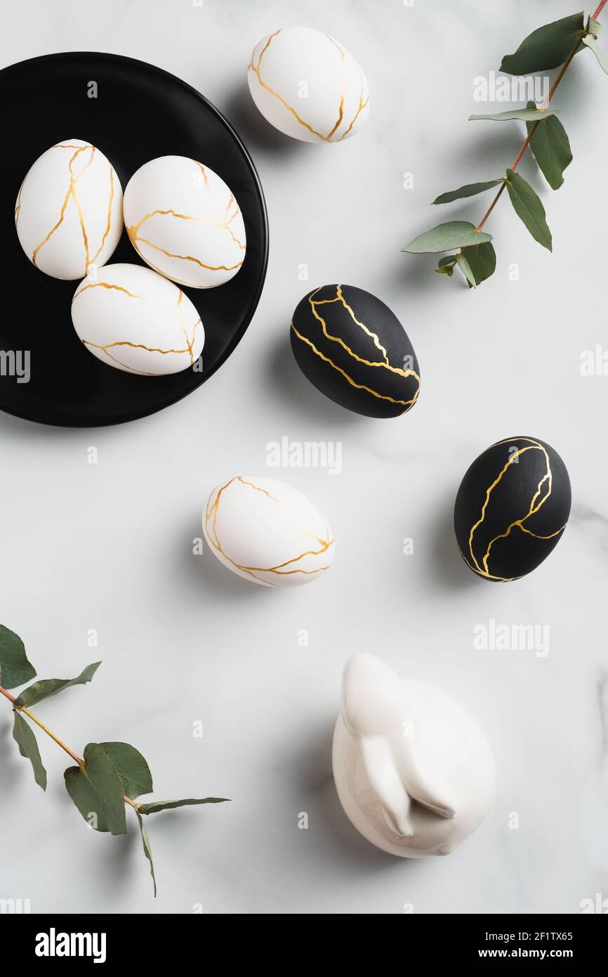 Luxury Easter flat lay composition with Easter eggs, eucalyptus leaves, bunny rabbit marble table. Happy Easter concept. Top view. Stock Photo