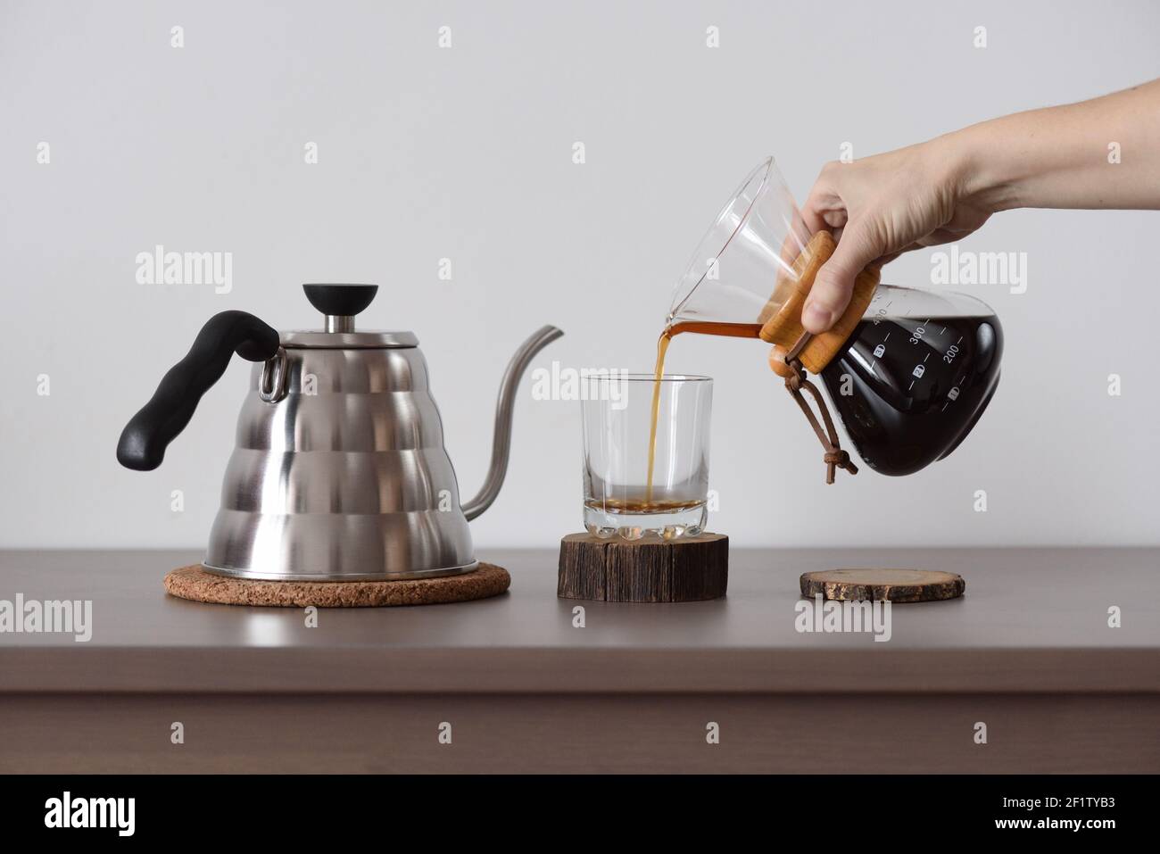 Brewing coffee in hand drip coffee maker. Woman hand pour coffee from