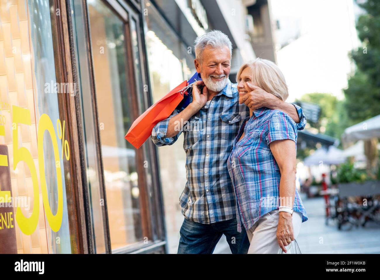 Happy senior couple in shopping looking at window Stock Photo