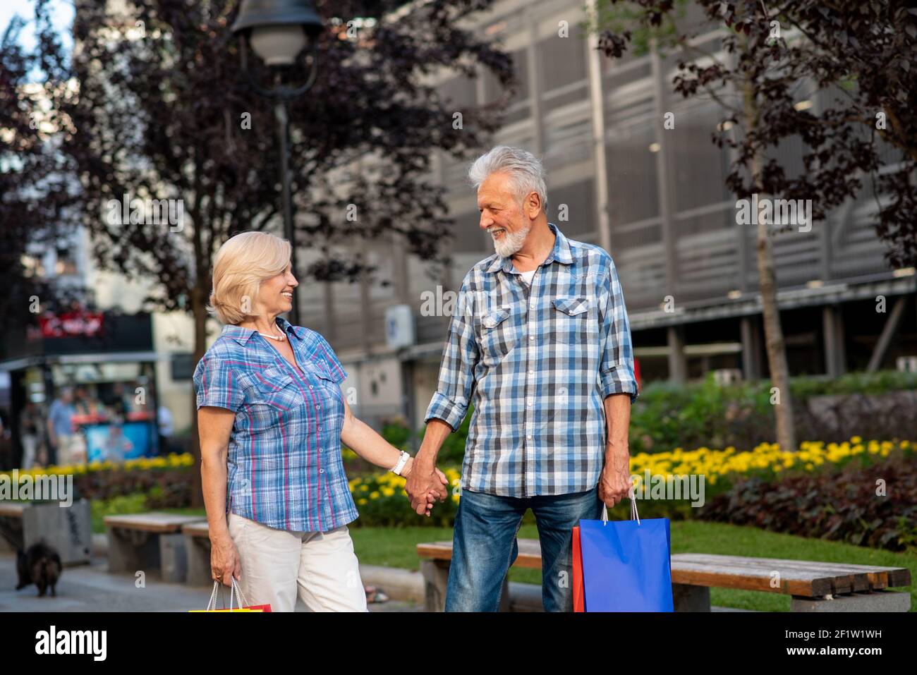Happy senior couple with shopping bags looking at each other Stock Photo