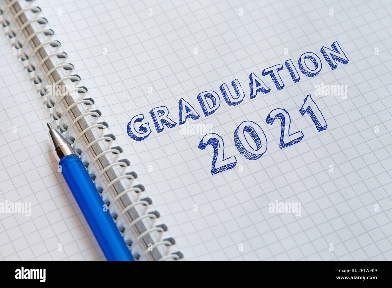 Text GRADUATION 2021 handwritten on sheet of notebook. Graduation day ...