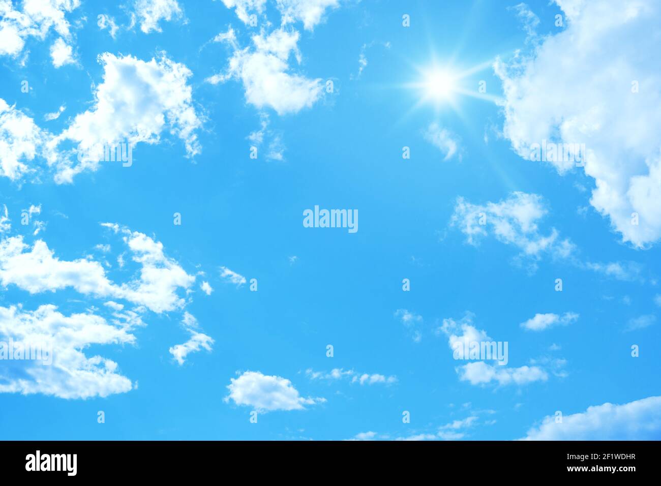 Typical blue sky with sun and clouds background Stock Photo