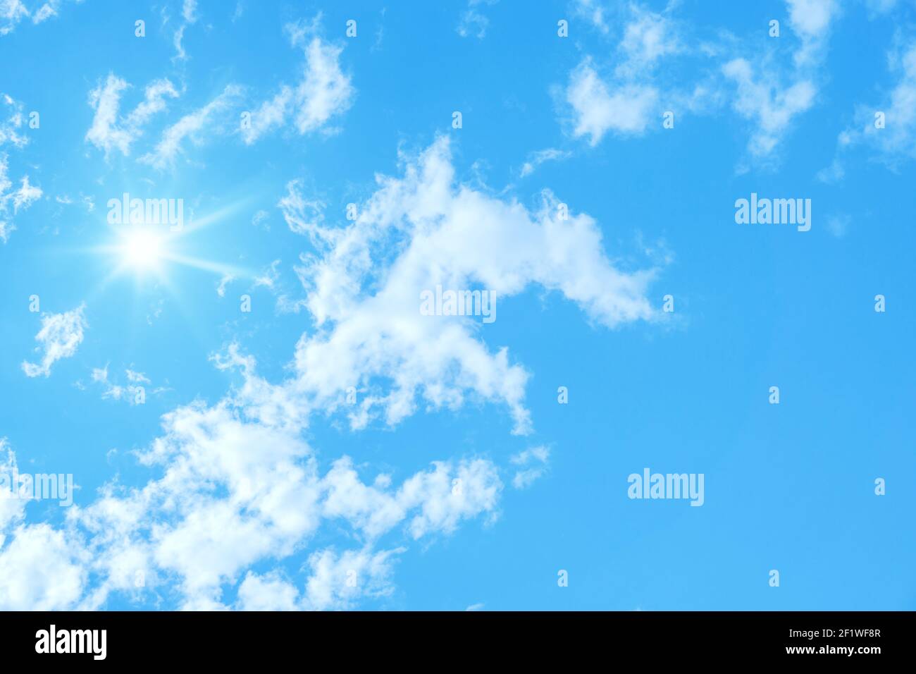 Typical blue sky with sun and clouds background Stock Photo