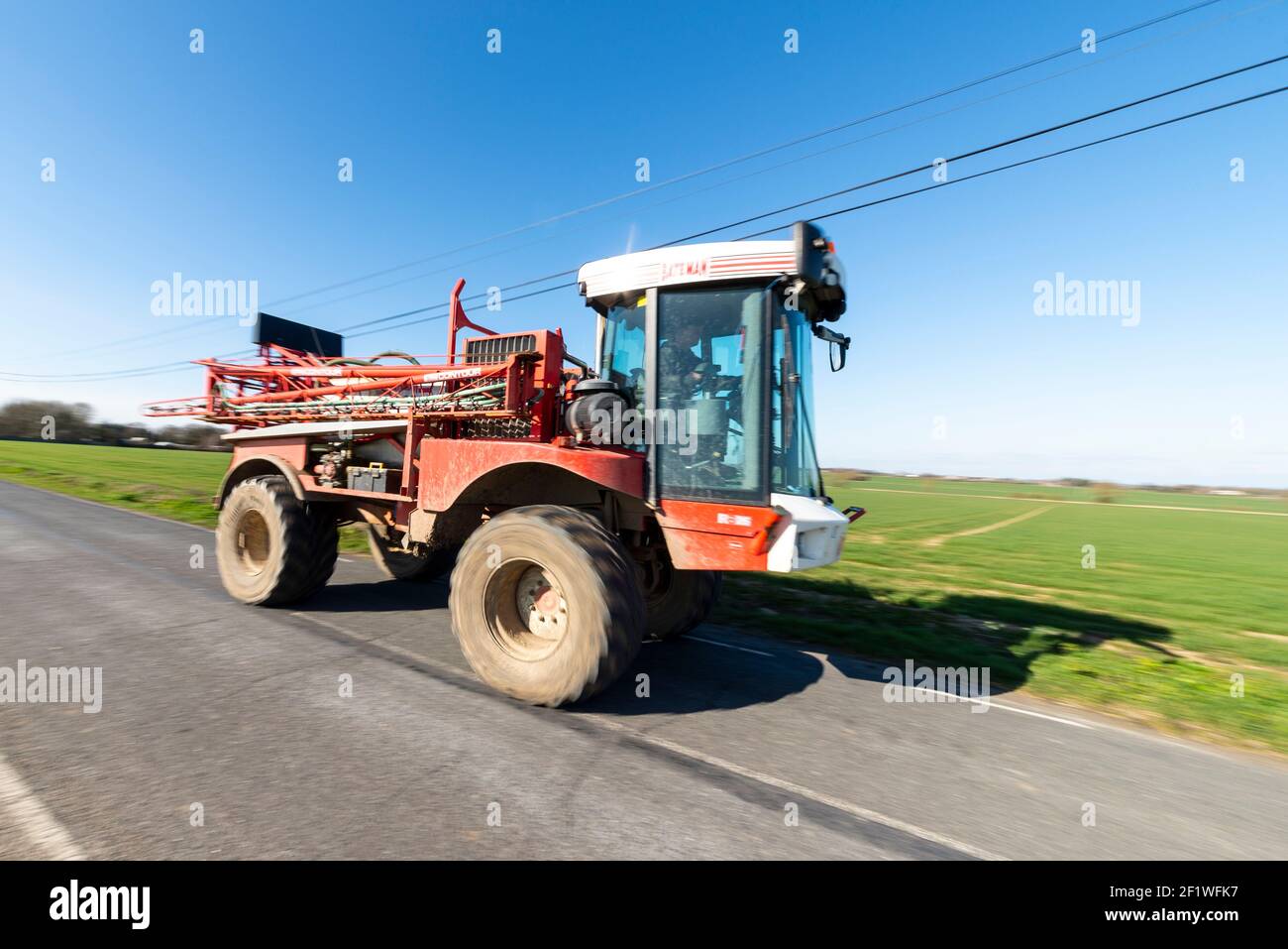 Bateman RB26 crop sprayer farm vehicle driving on Paglesham Road in the Essex coutryside, UK Stock Photo