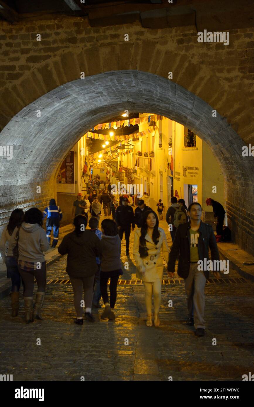 People walking under an arched bridge on the Calle Morales, La Ronda, Quito, Ecuador Stock Photo
