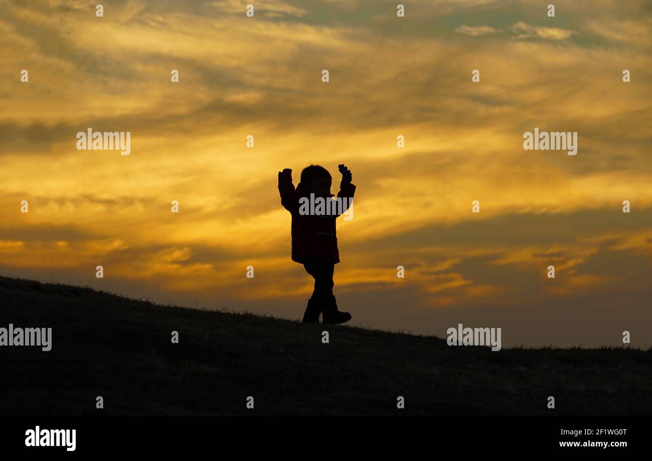 Boy standing in the twilight of the hill Stock Photo