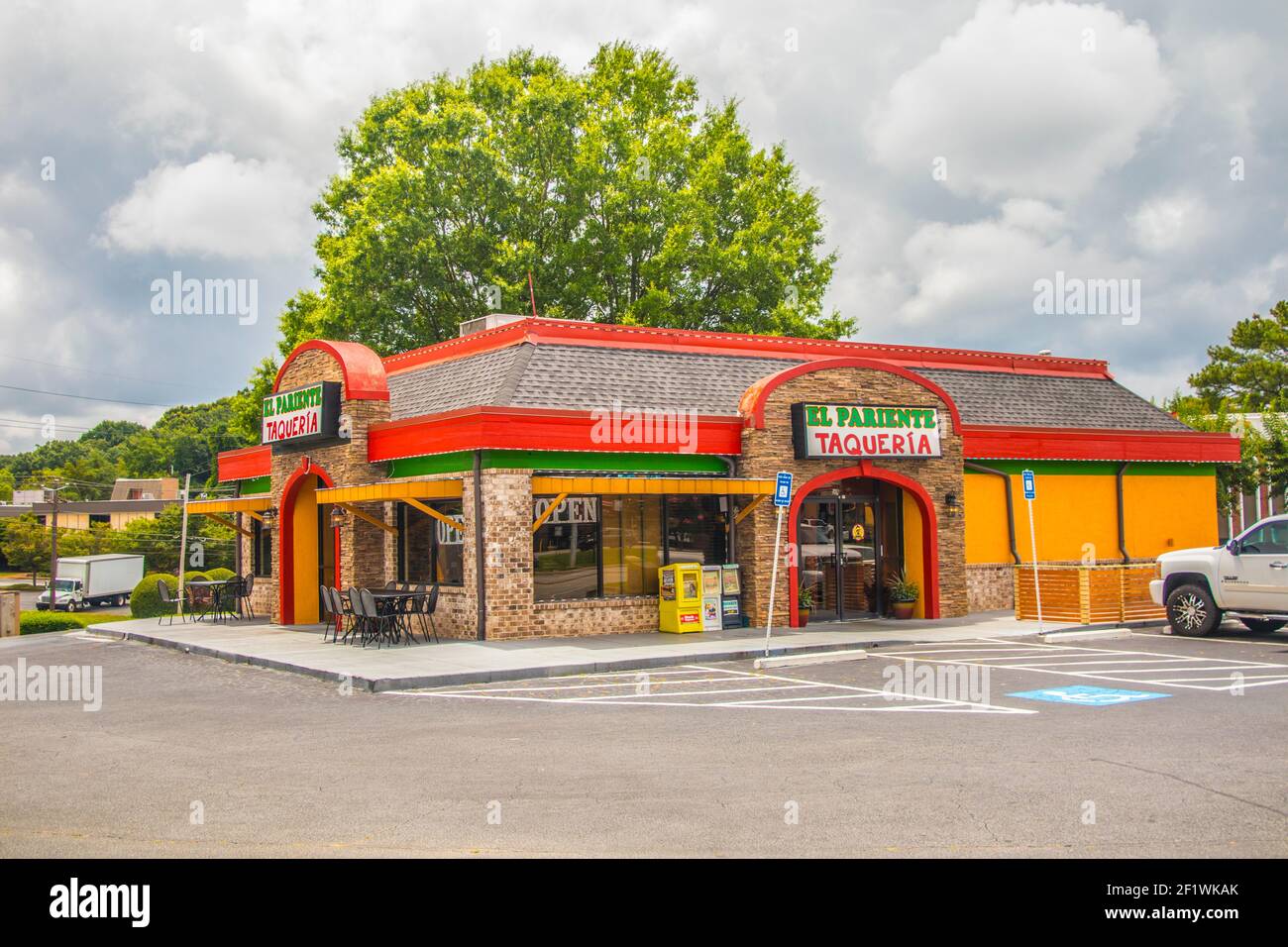 Doraville, Ga / USA - 07 06 20: Ethnic restaurant with a large green tree and cloudy sky Stock Photo
