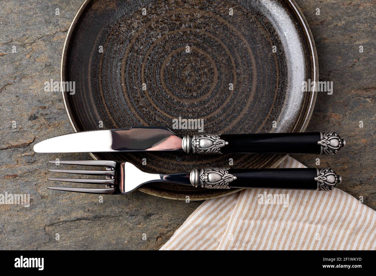 Plate, knife and fork on stone background Stock Photo
