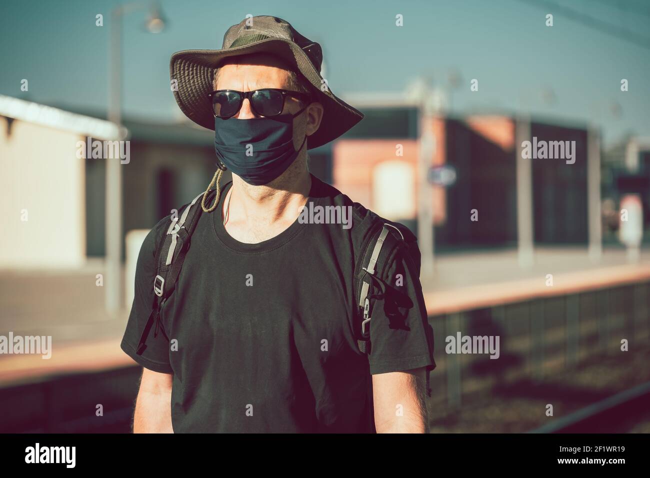 Man with a mask waiting for a train during Covid19 pandemic Stock Photo