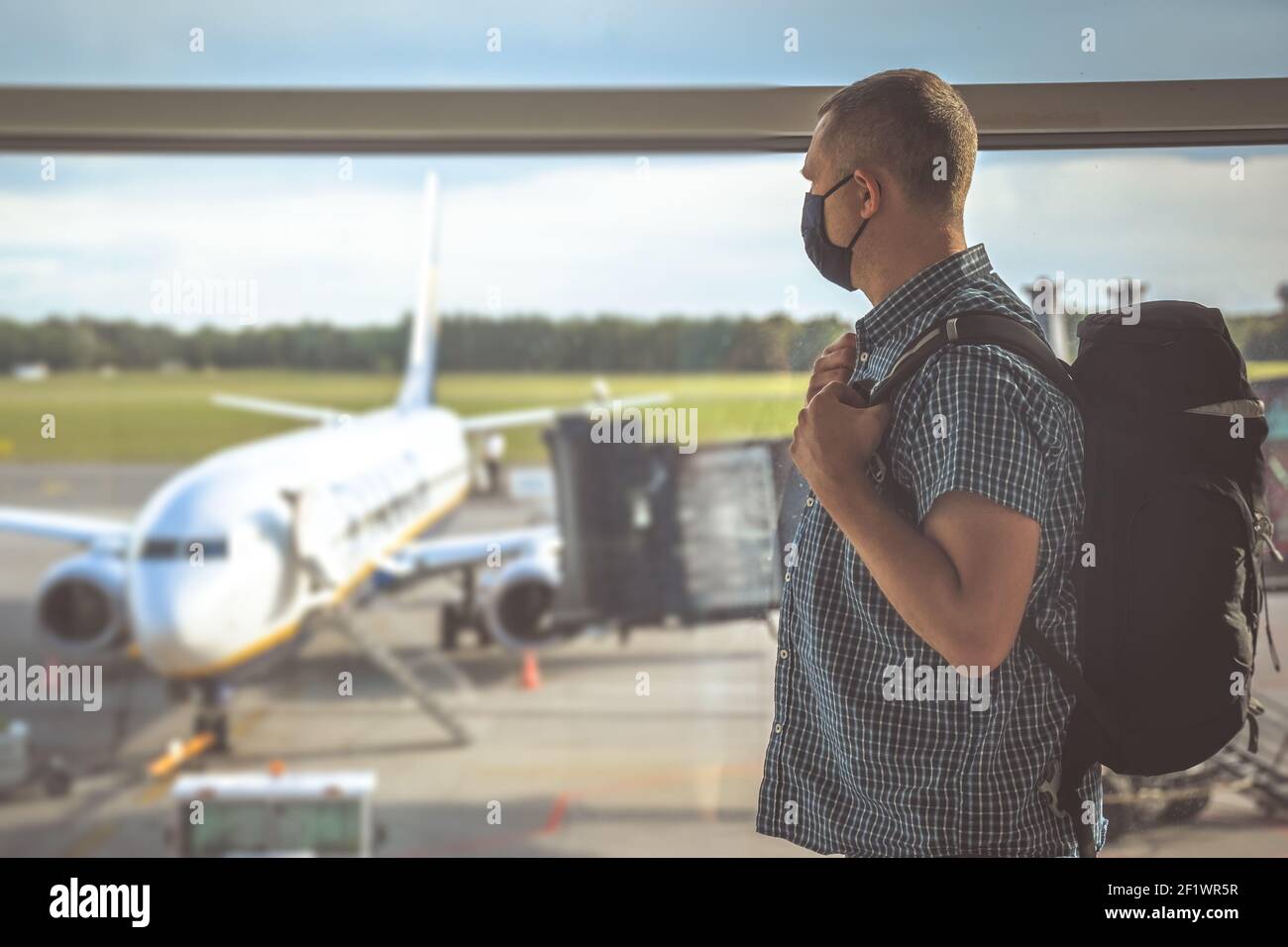 Man with a backpack waiting for departure in Covid19 time Stock Photo