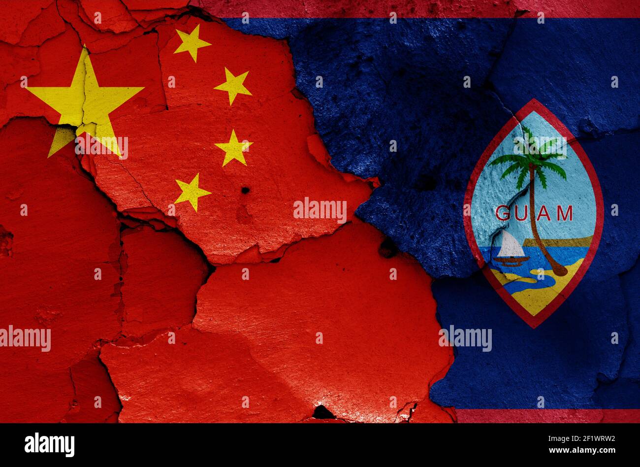 flags of China and Guam painted on cracked wall Stock Photo
