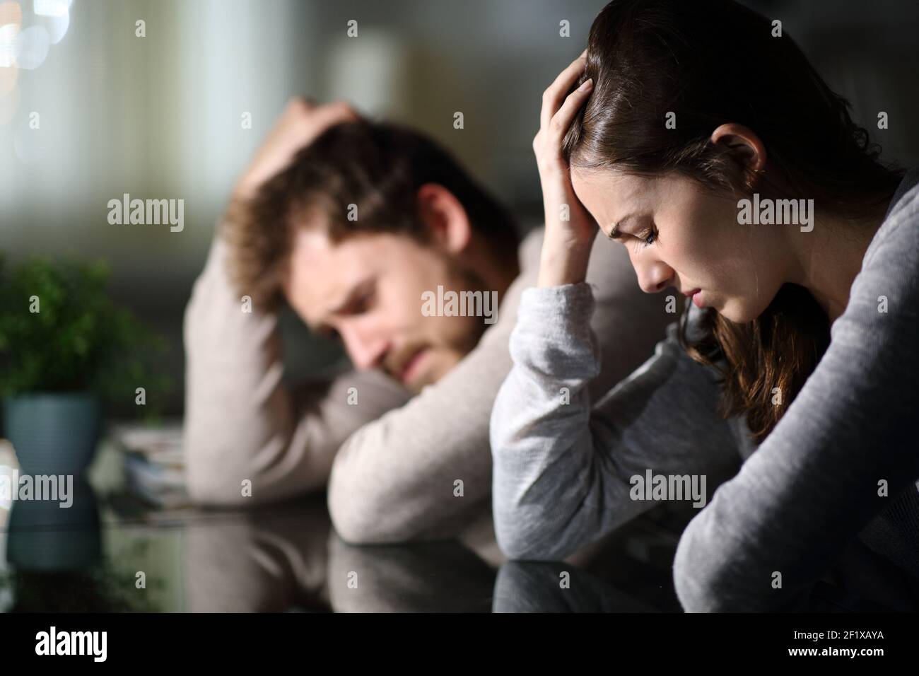 Sad couple complaining after argument in the night at home Stock Photo