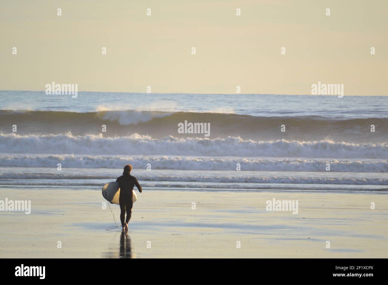 Lone surfer boy heading out for a wave. Stock Photo