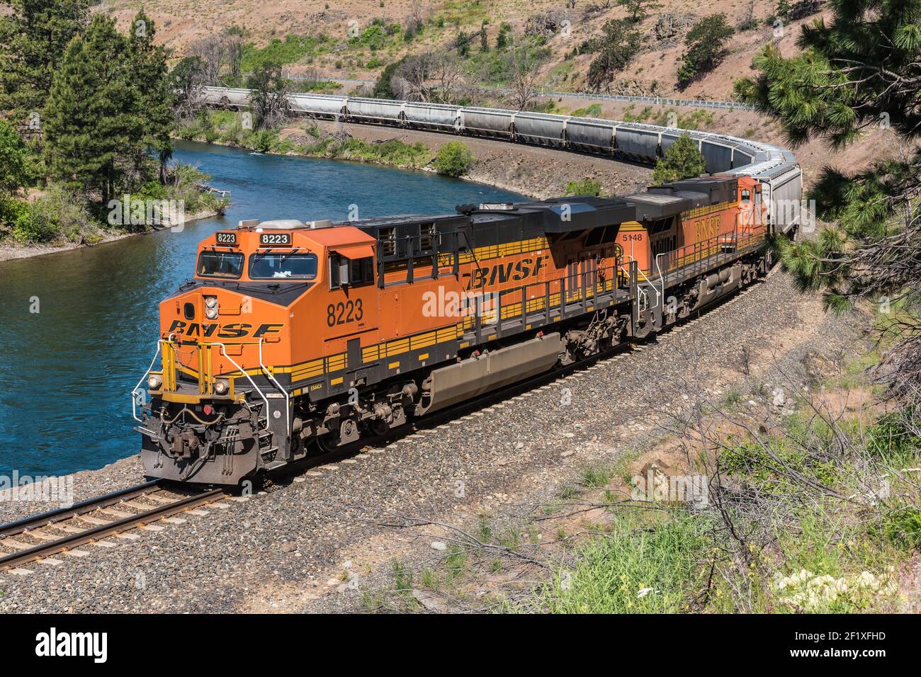 BNSF freight train heads east alongside the Yakima River near Ellensburg in Washington State Stock Photo