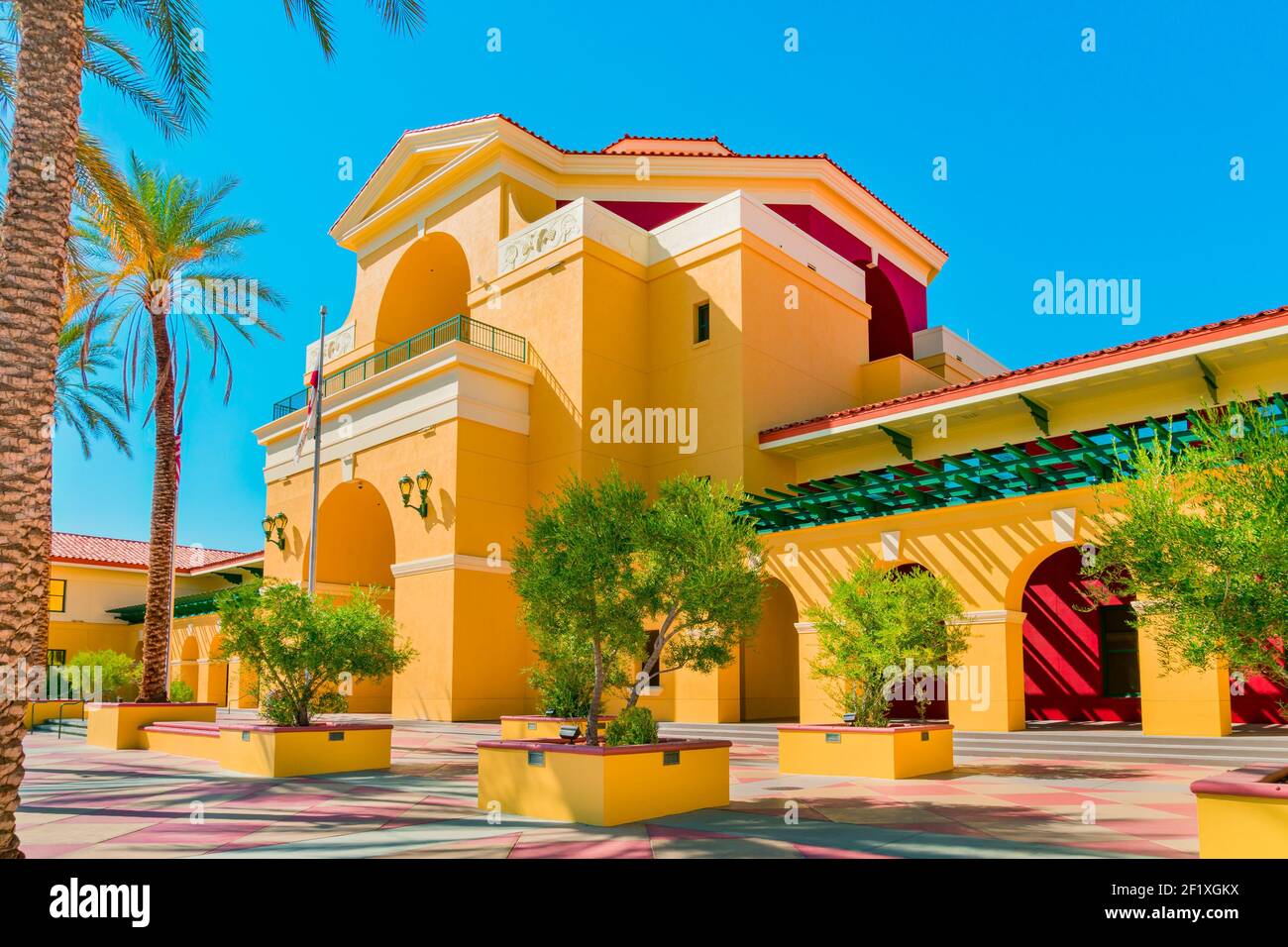 Palm trees and vegetation surround the arch ways of the Civic Center building of the Cathedral City and Palm Springs area. Stock Photo