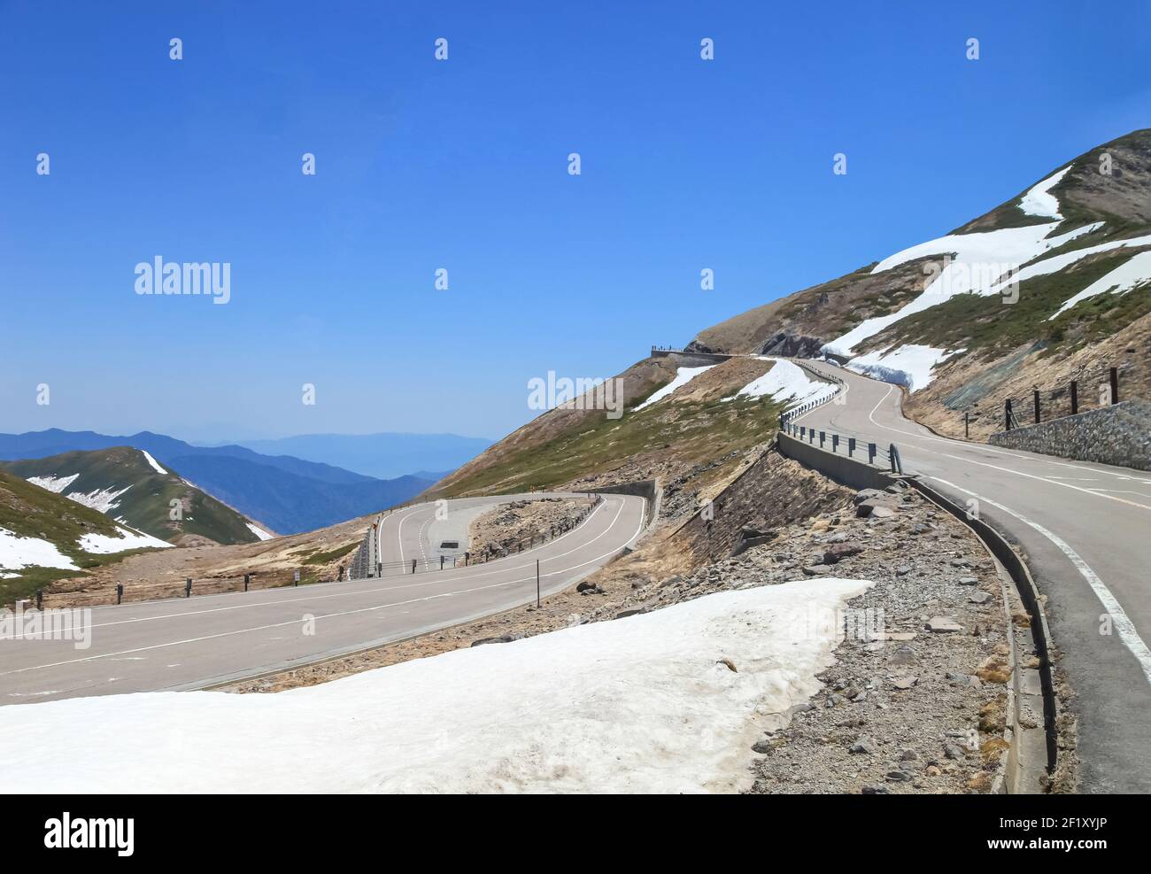 Tateyama Kurobe Alpine Route with beautiful landscape snow mountains., the tourists bus move along the japan alps snow wall with blue sky background. Stock Photo