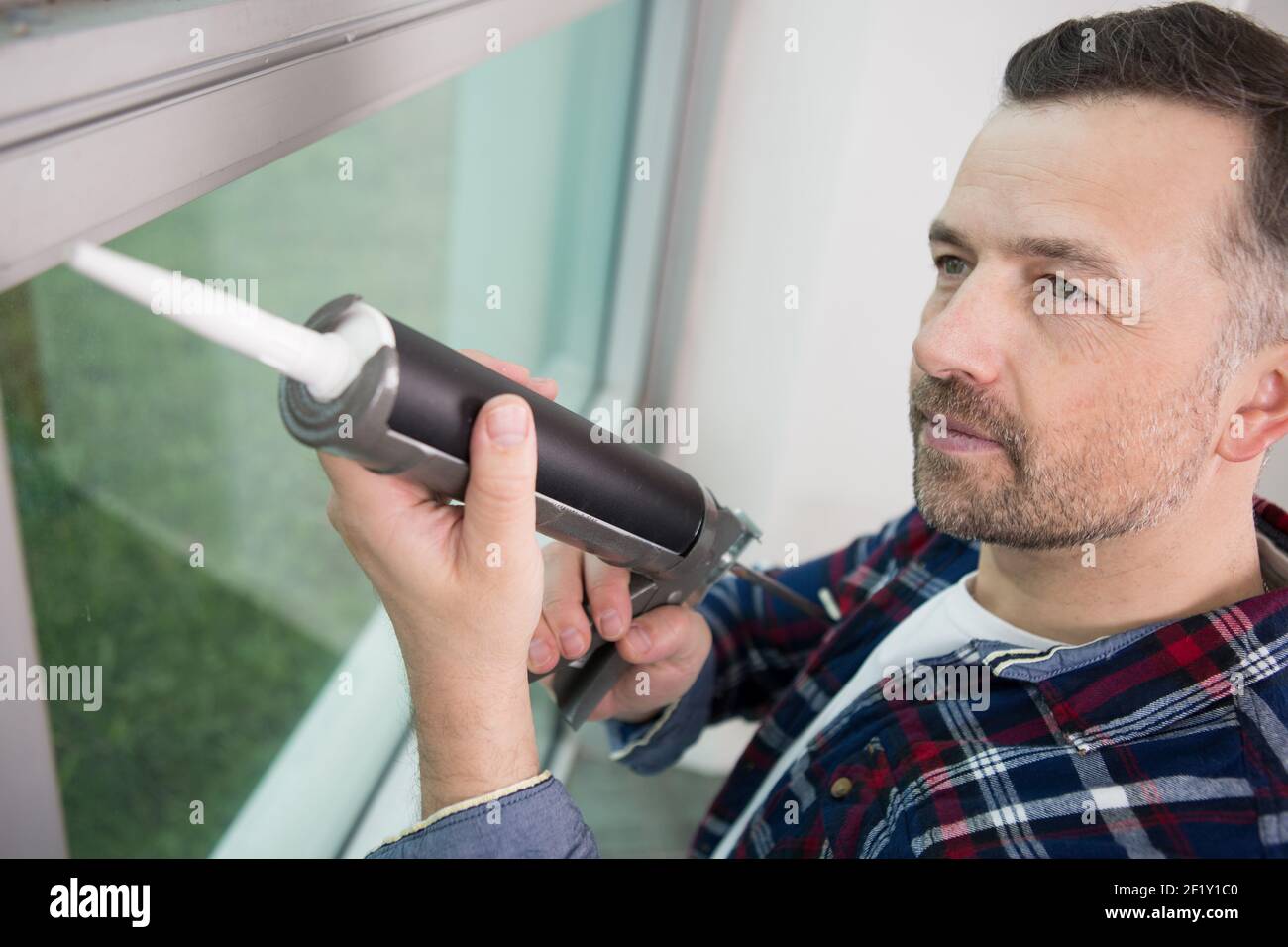 man caulking window with a caulk gun Stock Photo Alamy