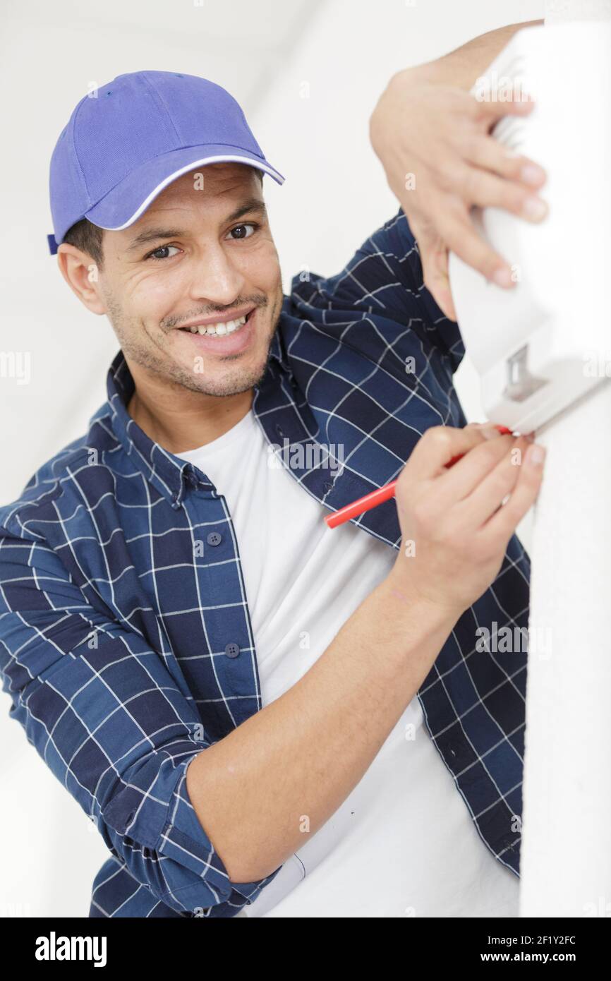 man builder installing devices indoors Stock Photo