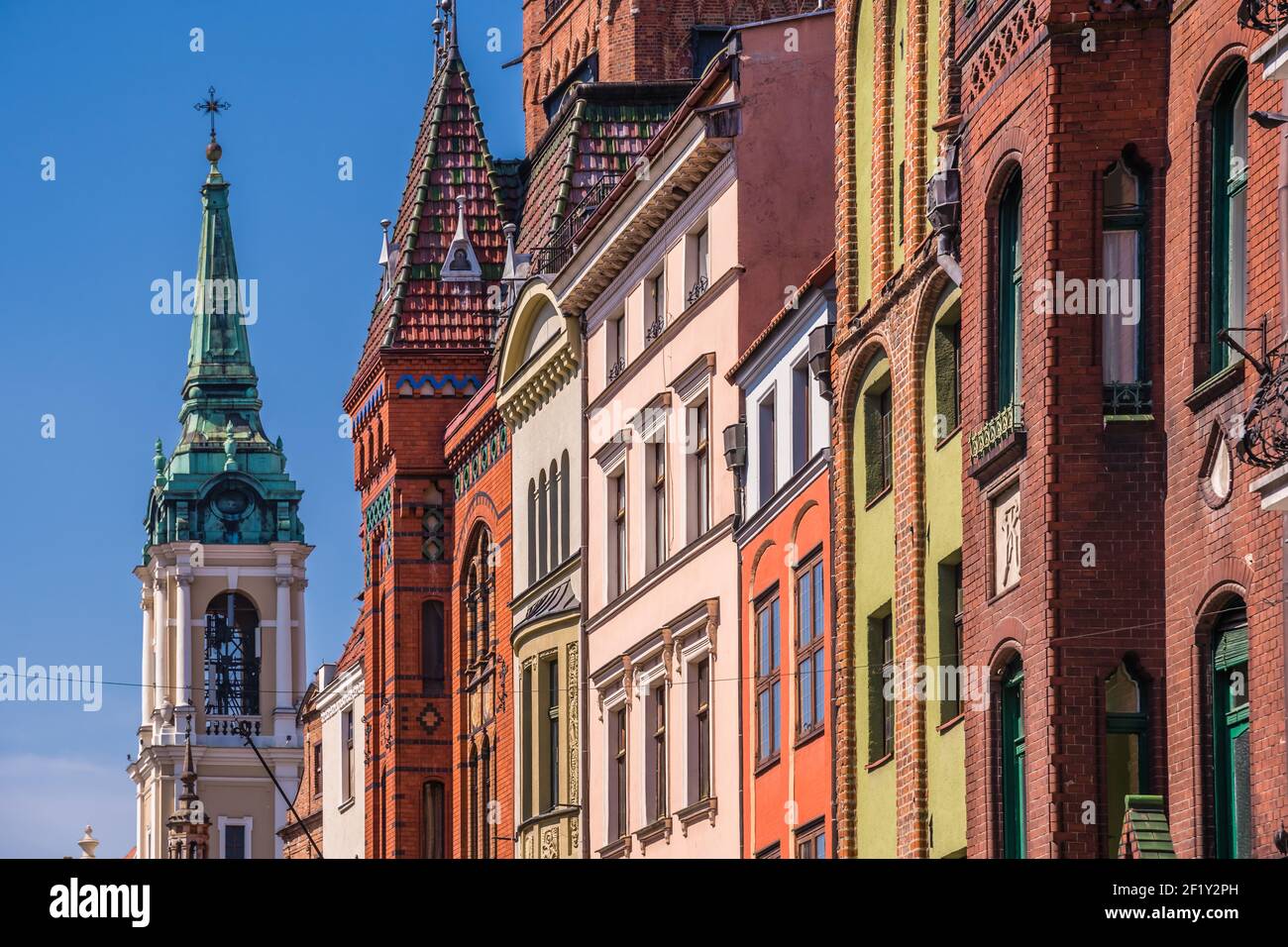 Church of the Holy Spirit surrounded by buildings under the sunlight and a blue sky in Torun, Poland Stock Photo