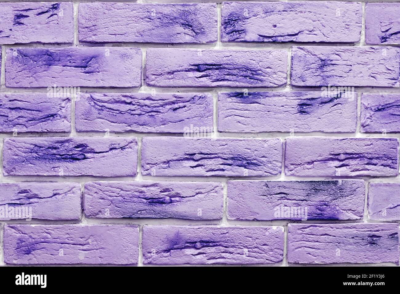Seamless background pattern of lush purple decorative bricks on the wall. Interior design and materials Stock Photo