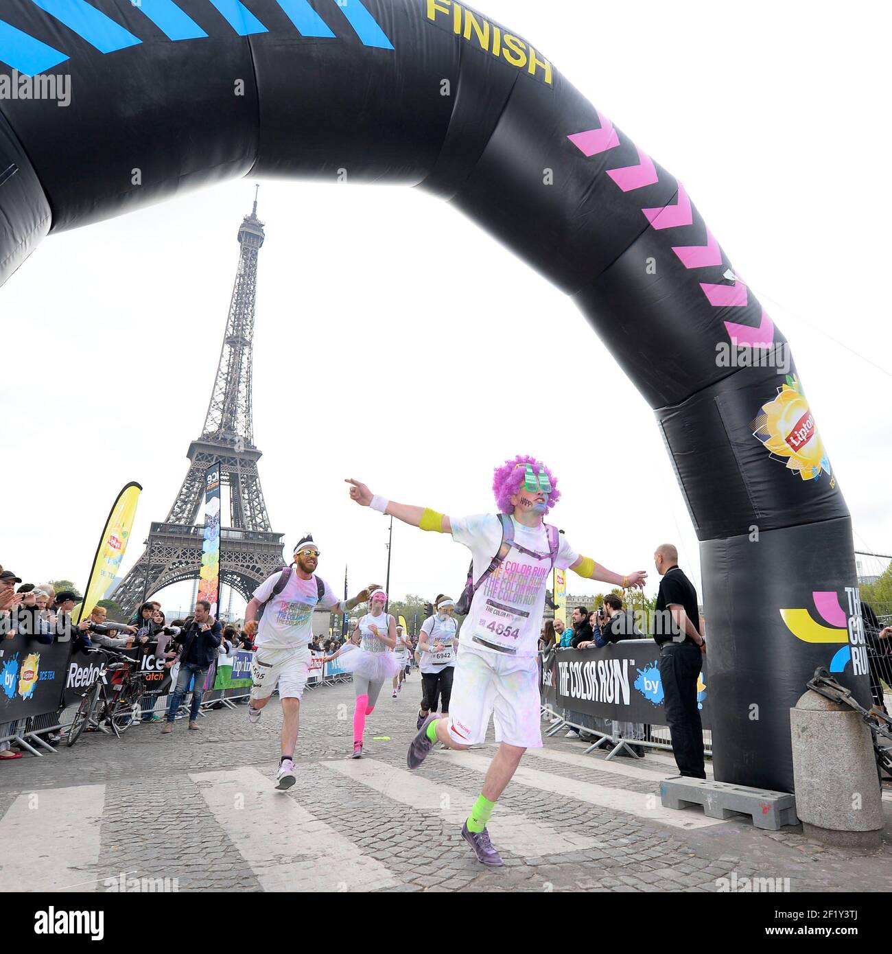 Runners throw coloured powder in the air at the finish line during the ...