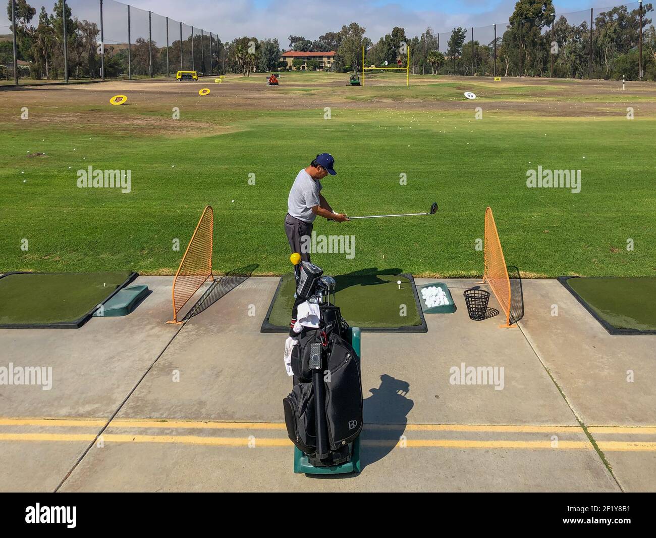 Golfer practicing at golf driving range practice facility Stock Photo