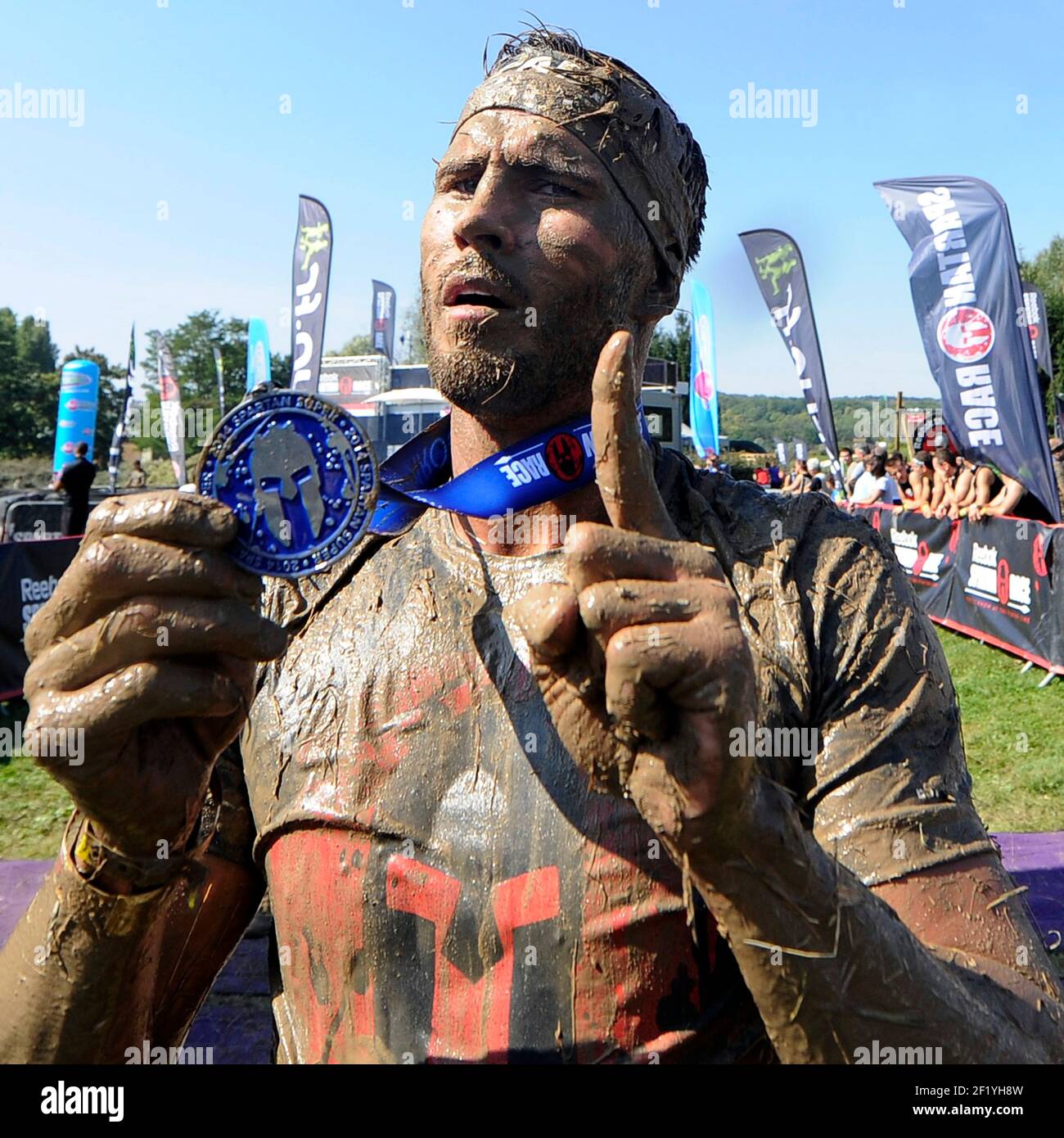 The French boxer Alexis Vastine shows his medal after the finish line of  the Reebok Spartan Race in Paris, on September 13, 2014. The Spartan Race  is a race in the mud