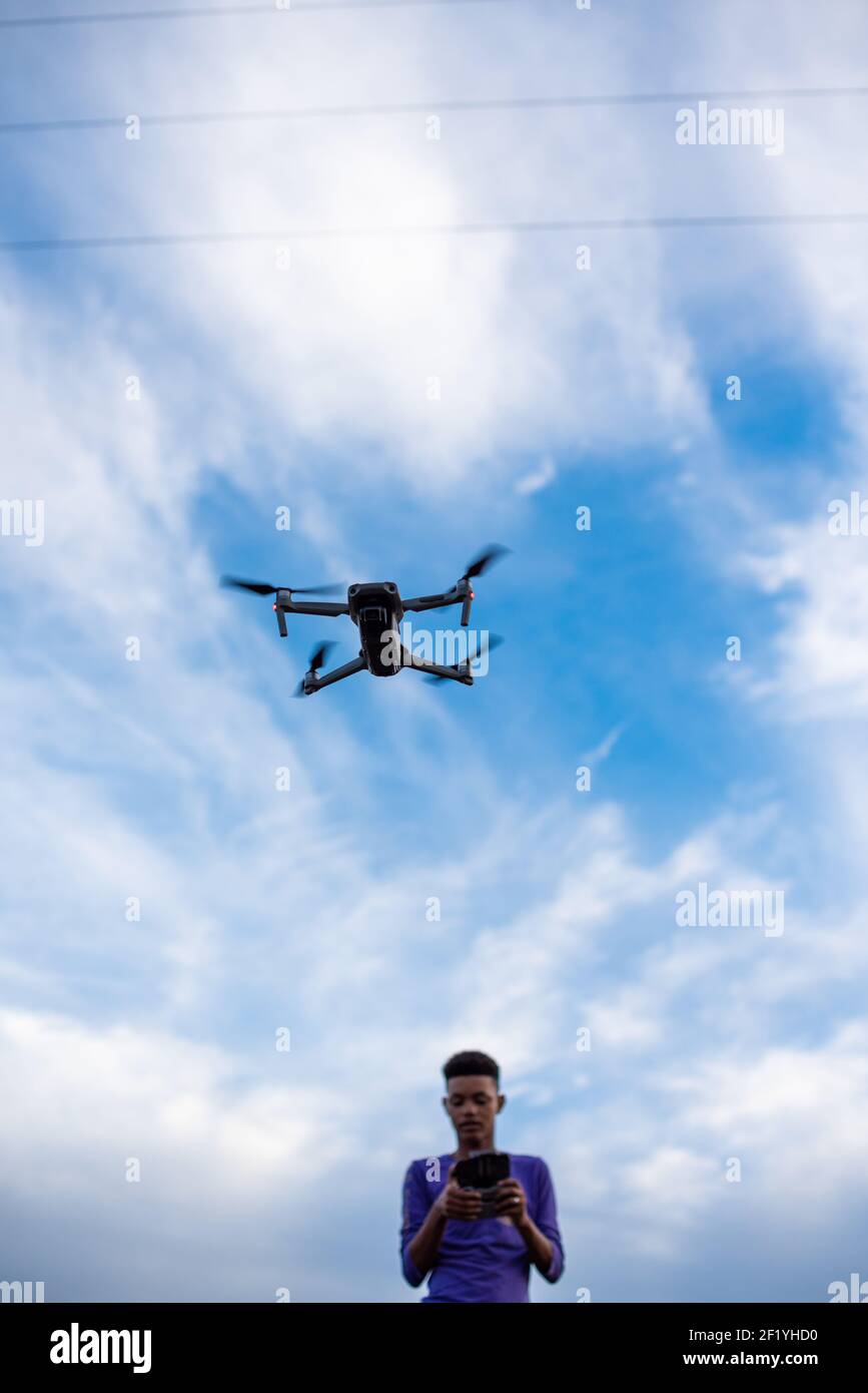 Young boy seen flying a drone outdoors Stock Photo