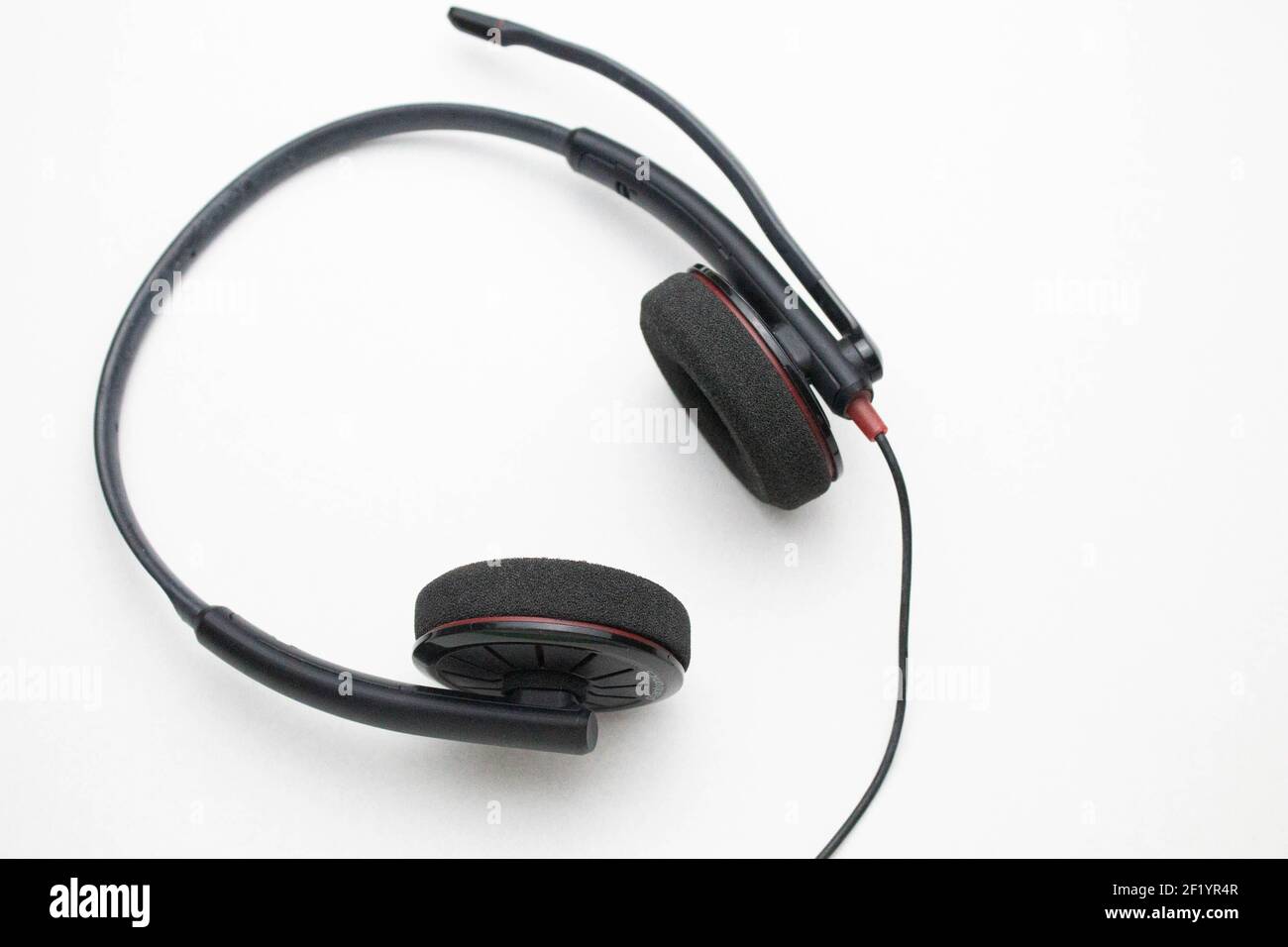Headphones with microphone on a white background. Headphones for negotiations on the table. Stock Photo