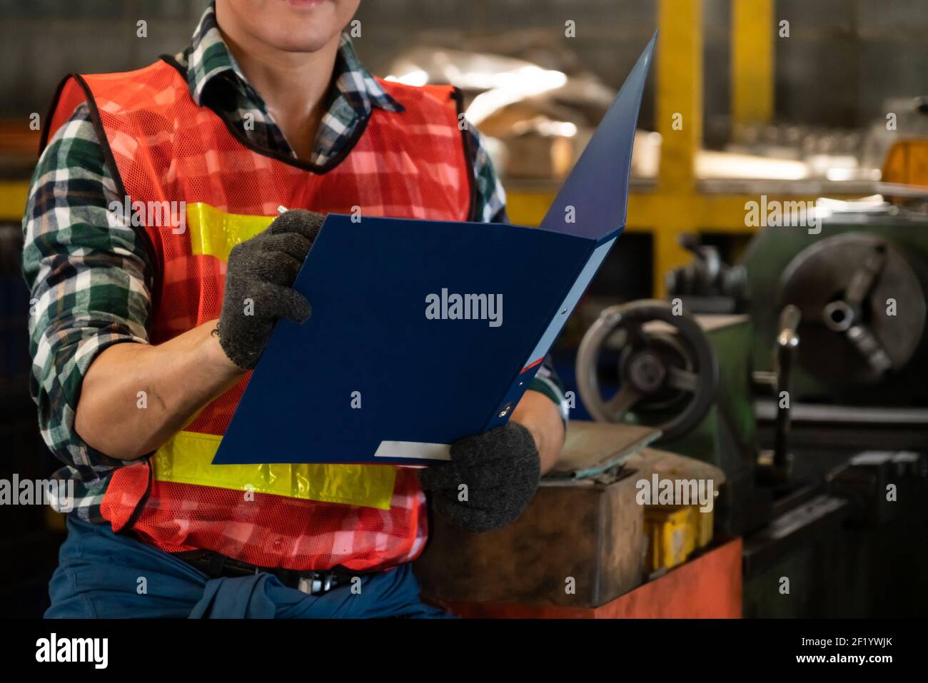 Manufacturing worker working with clipboard to do job procedure
