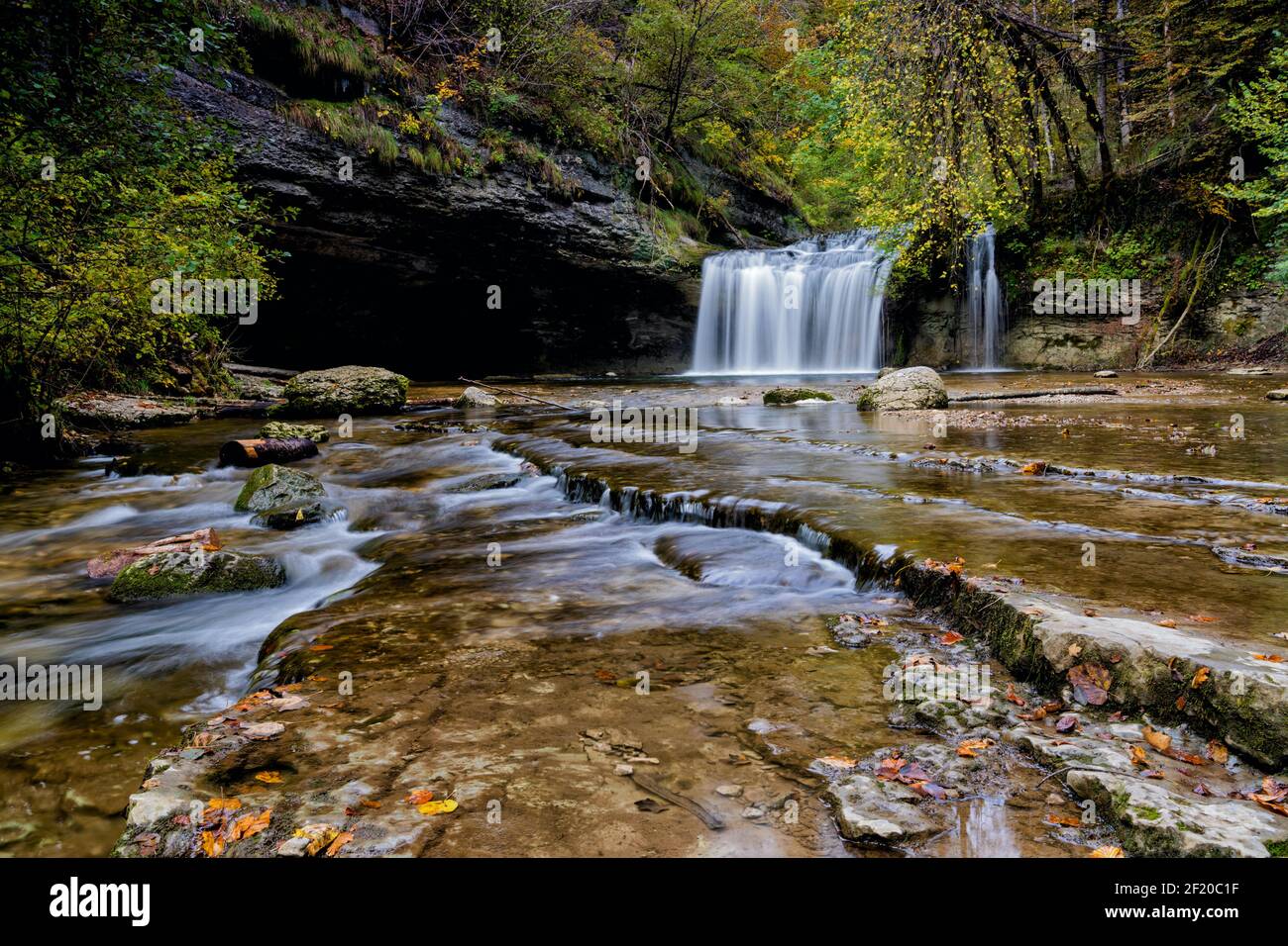 A beautiful autumn forest landscape with idyllic waterfall and river steps Stock Photo