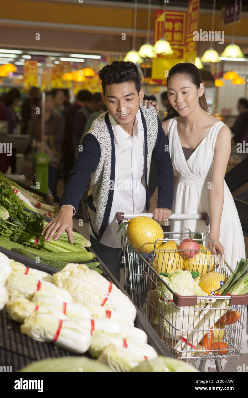 A young couple in the supermarket shopping Stock Photo