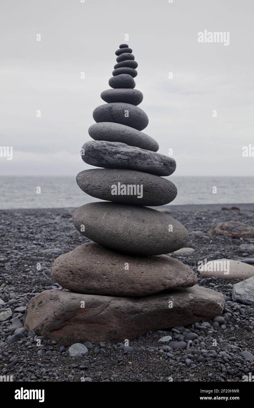 Stacked stones in balance on a black lava beach, DjÃºpalÃ³nssandur, SnÃ¦fellsnes, West Iceland, Iceland Stock Photo
