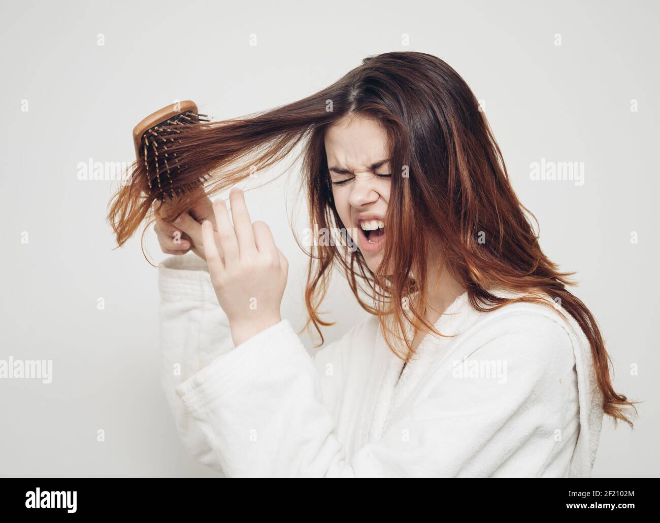 woman combing hair brittle ends split ends health problems Stock Photo