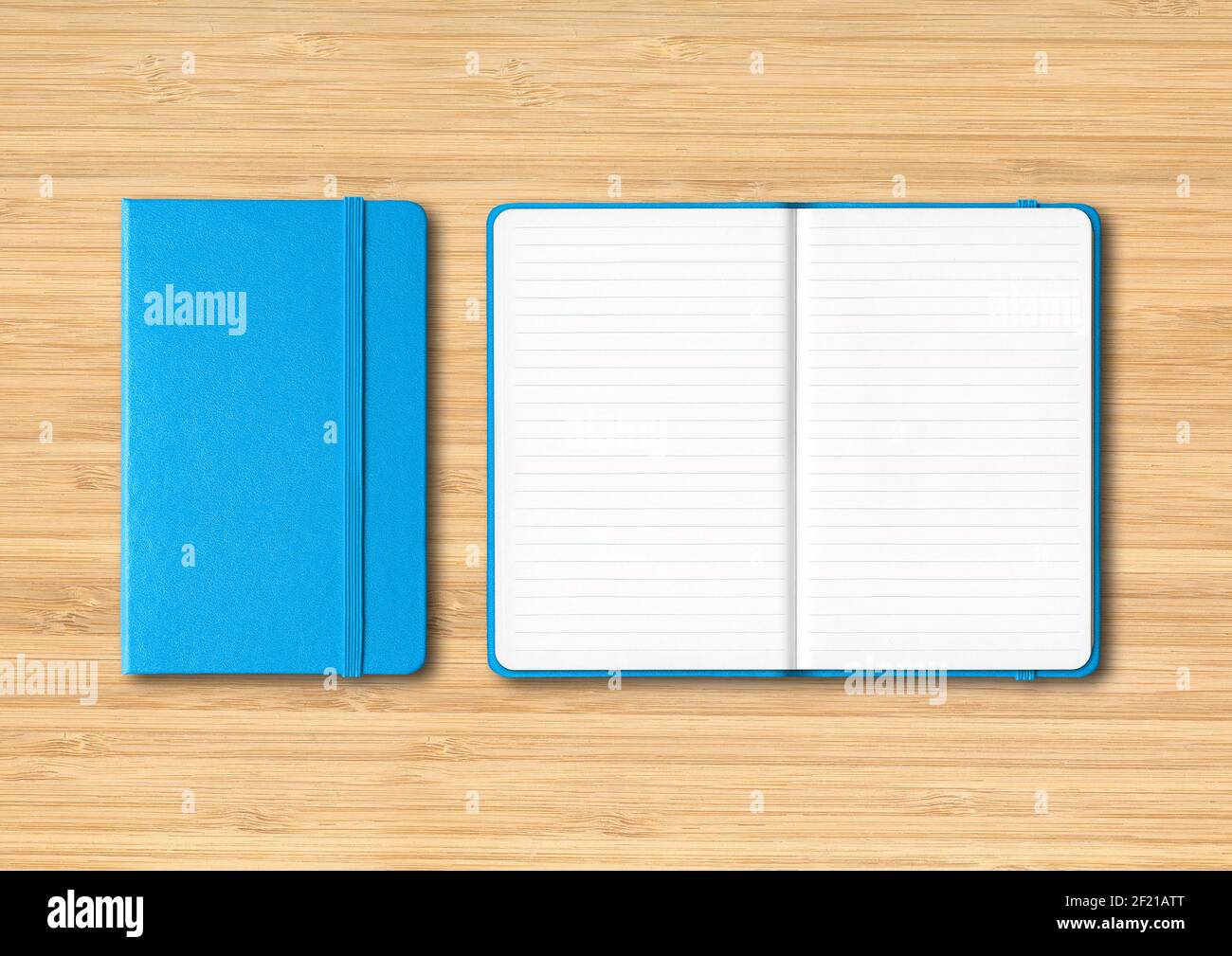 Blue closed and open lined notebooks on wooden background Stock Photo