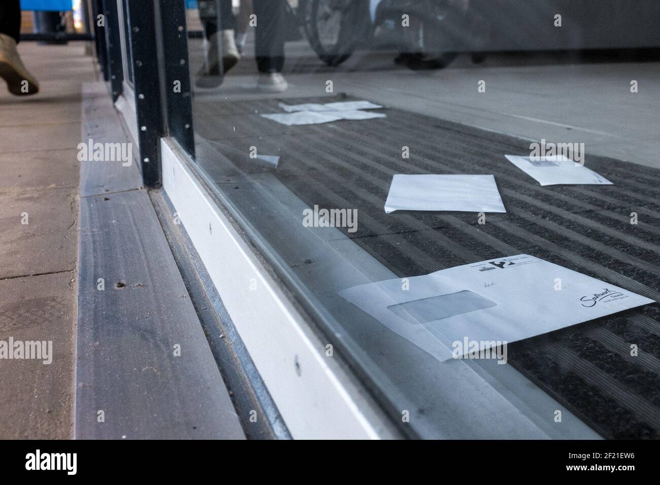 Uncollected letters and post behind a glass door on the Southbank, London, UK Stock Photo