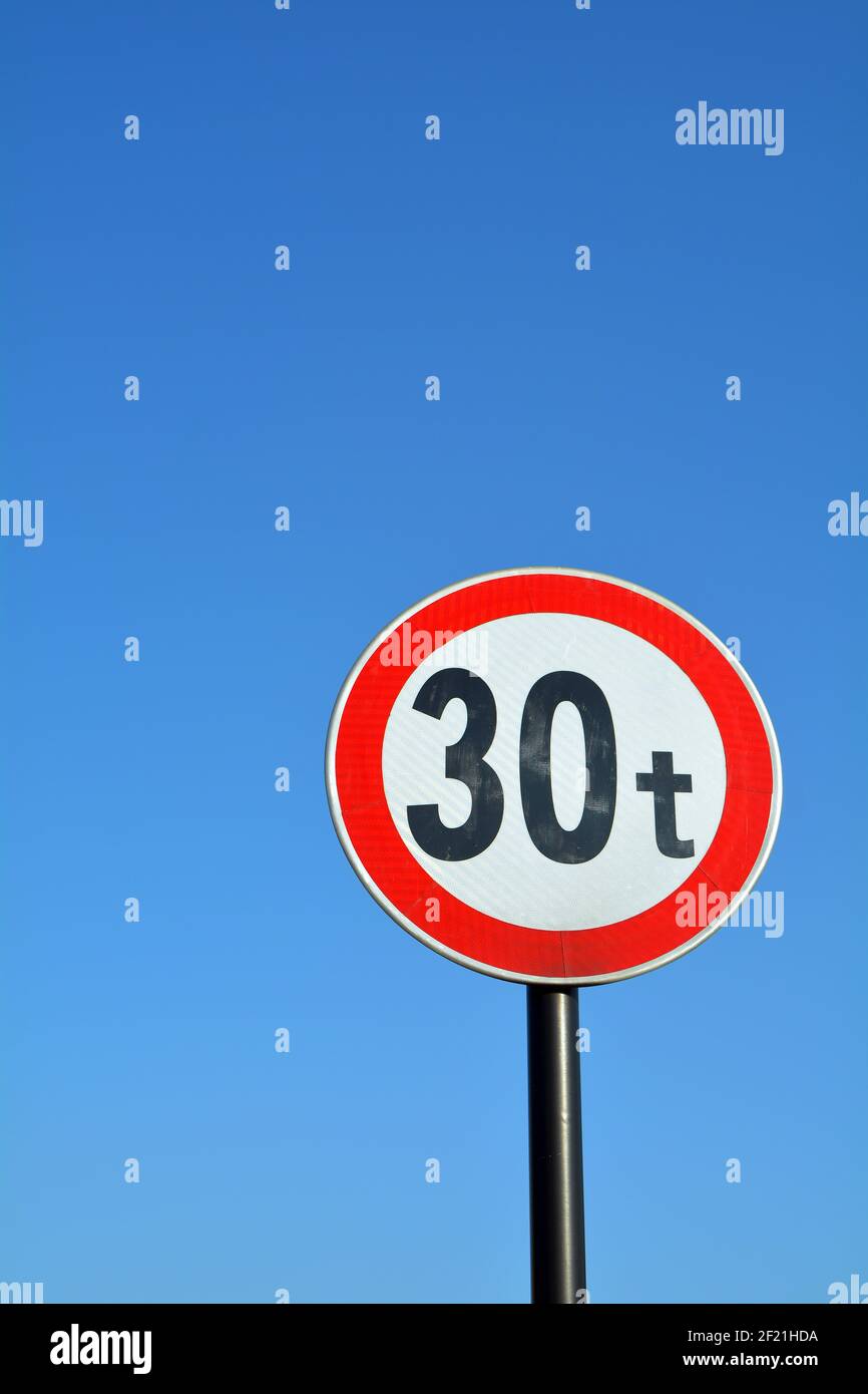 Red and white 30 ton sign against a plain blue sky Stock Photo - Alamy