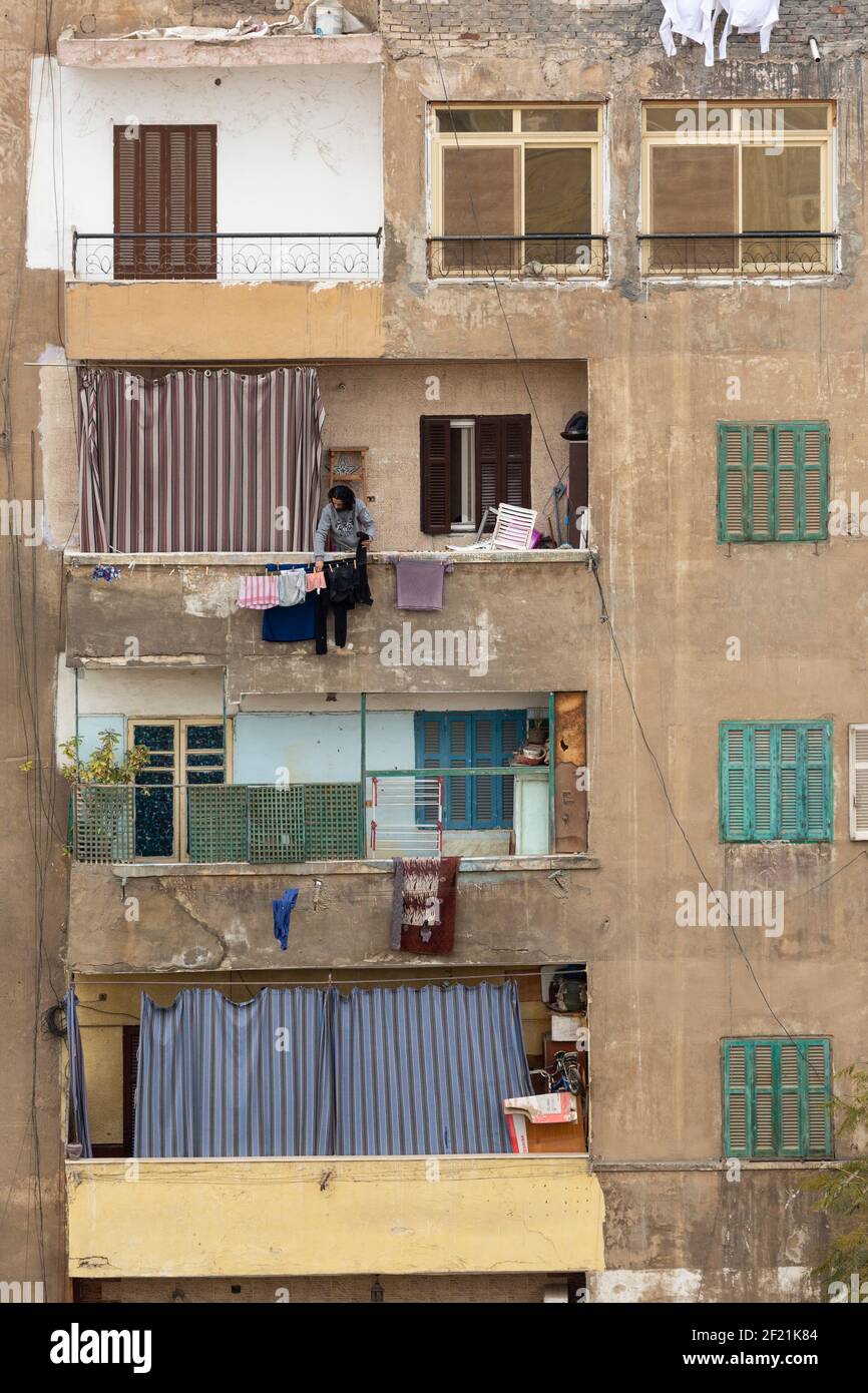 A local Egyptian man hanging out washing to dry on an upper-storey terrace in Tolon, El-Sayeda Zainab, Cairo, Egypt Stock Photo