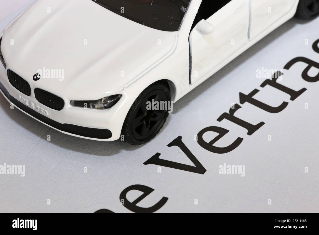 Symbol picture car insurance: Model car with contract documents (german) Stock Photo