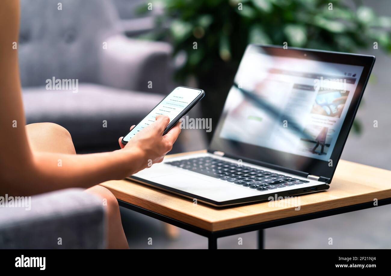 Wireless wifi for remote work in airport lounge bar, hotel lobby or cafe. Phone and laptop. Woman using smartphone and modern notebook pc computer. Stock Photo
