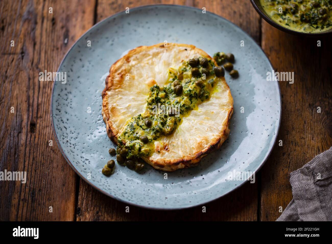 Roasted celeriac steak with capers and herb sauce Stock Photo Alamy
