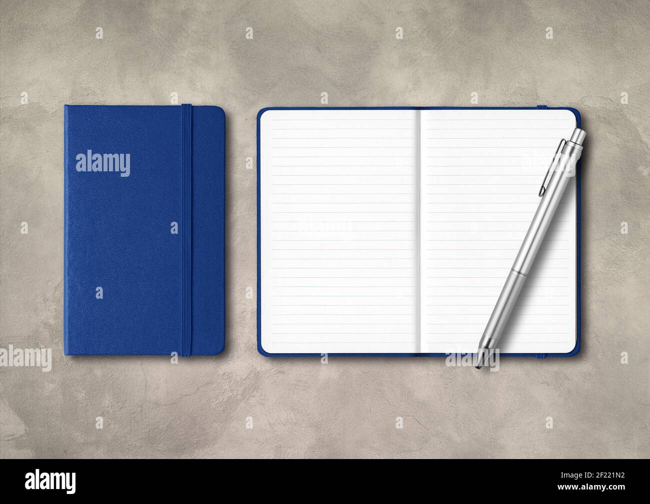 Marine blue closed and open lined notebooks with a pen on concrete background Stock Photo