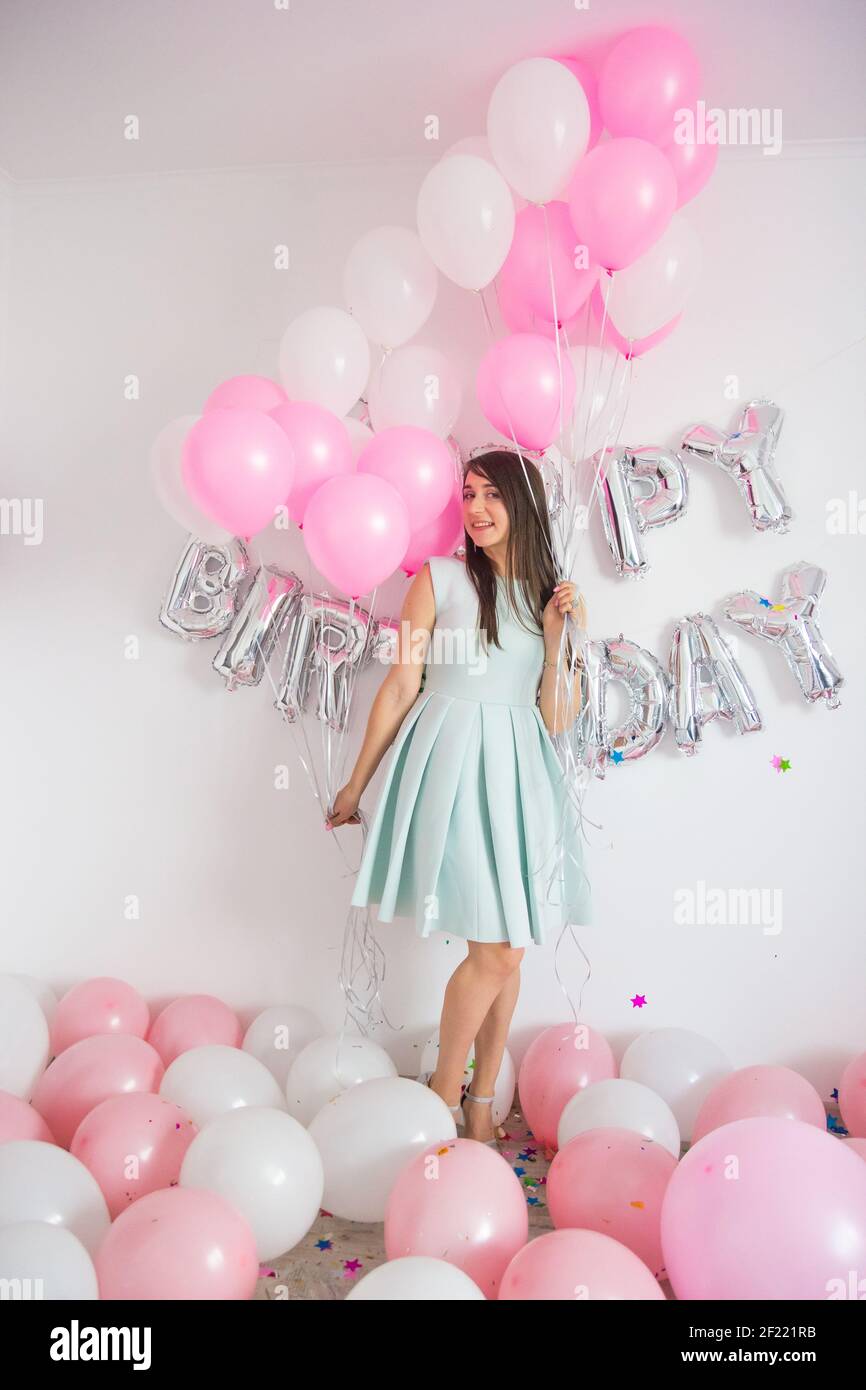 Graceful slim birthday girl in black dress posing with black, white, blue  and gray balloons. Full-length portrait of adorable laughing birthday girl  Stock Photo - Alamy