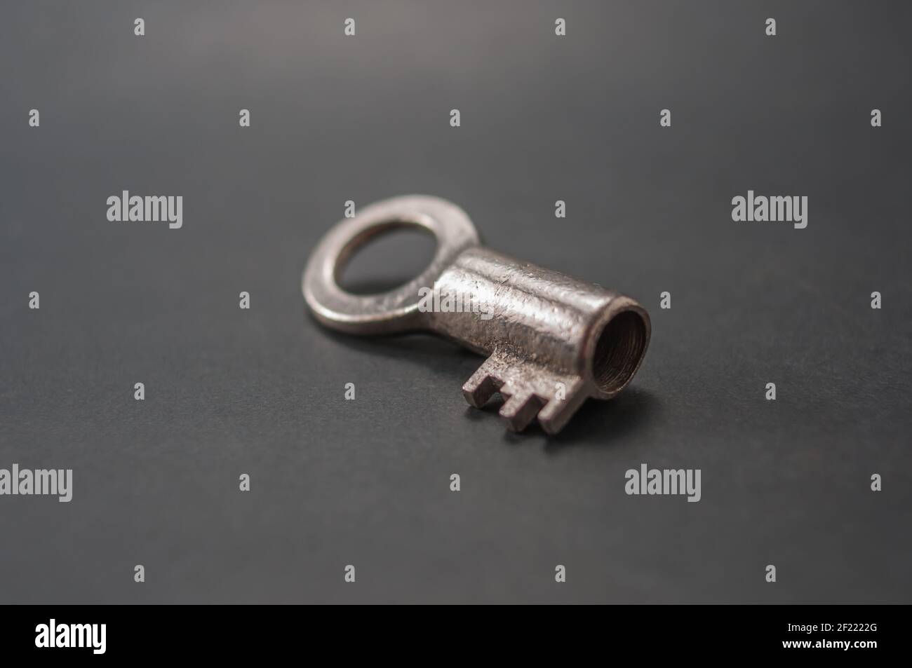 Small key from an old padlock on a black background Stock Photo