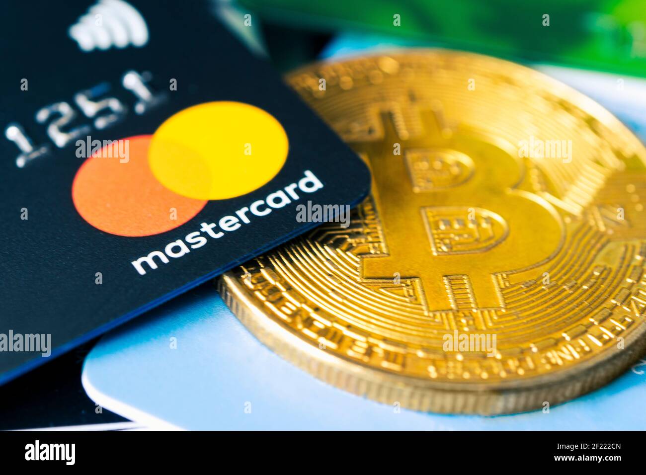 Gold bitcoin symbol and credit card master cards on the table. February 20, 2021, Barnaul, Russia Stock Photo