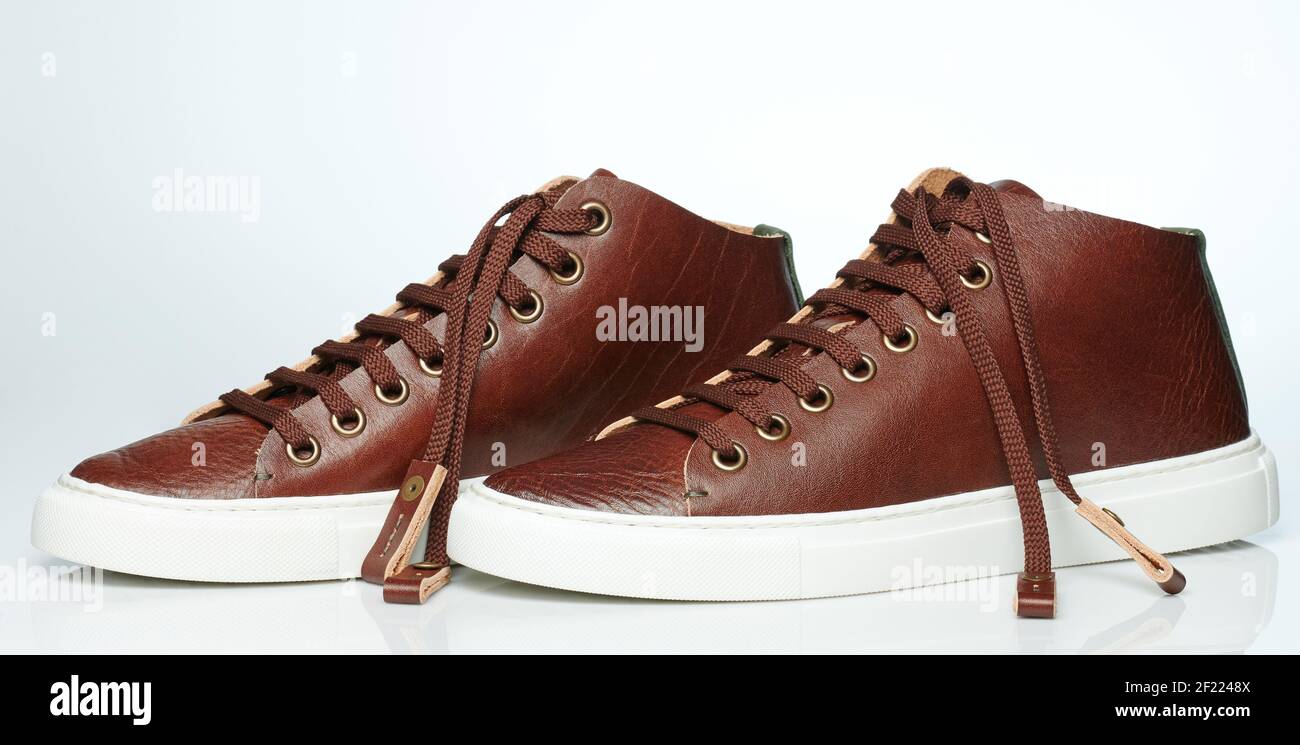 Side of brown pair of casual sneakers isolated on white studio background Stock Photo
