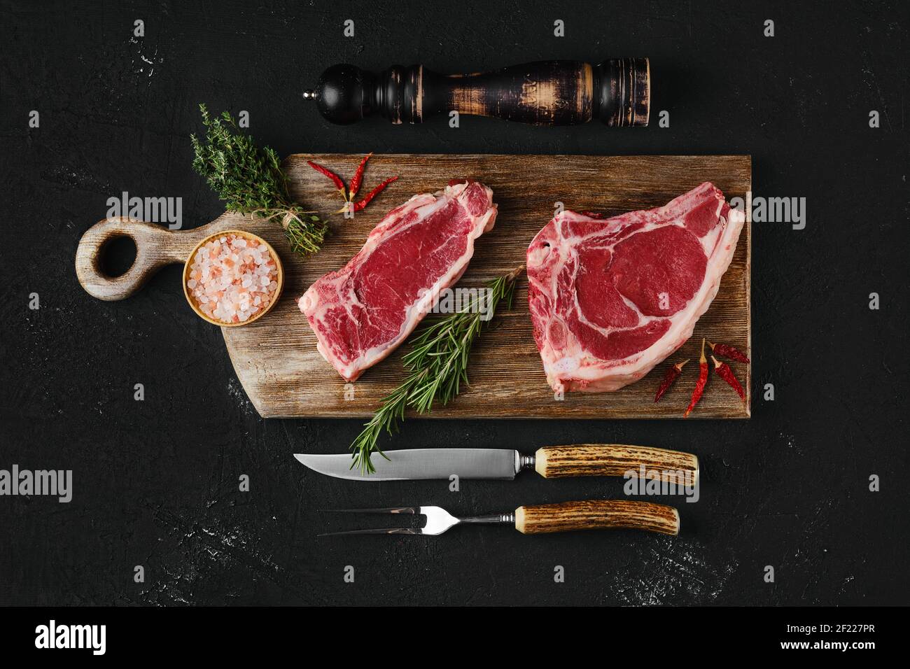 Raw strip steak bone in and boneless on dark background Stock Photo Alamy