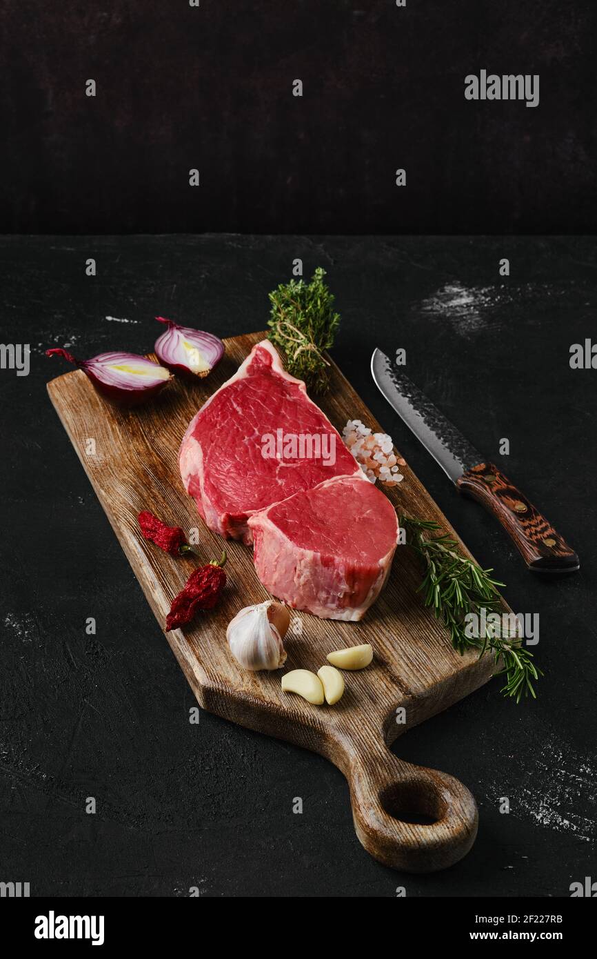 Raw top sirloin beef steak on wooden cutting board Stock Photo