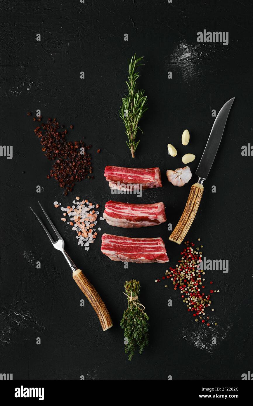 Top view of raw beef short ribs, bone in on dark background Stock Photo